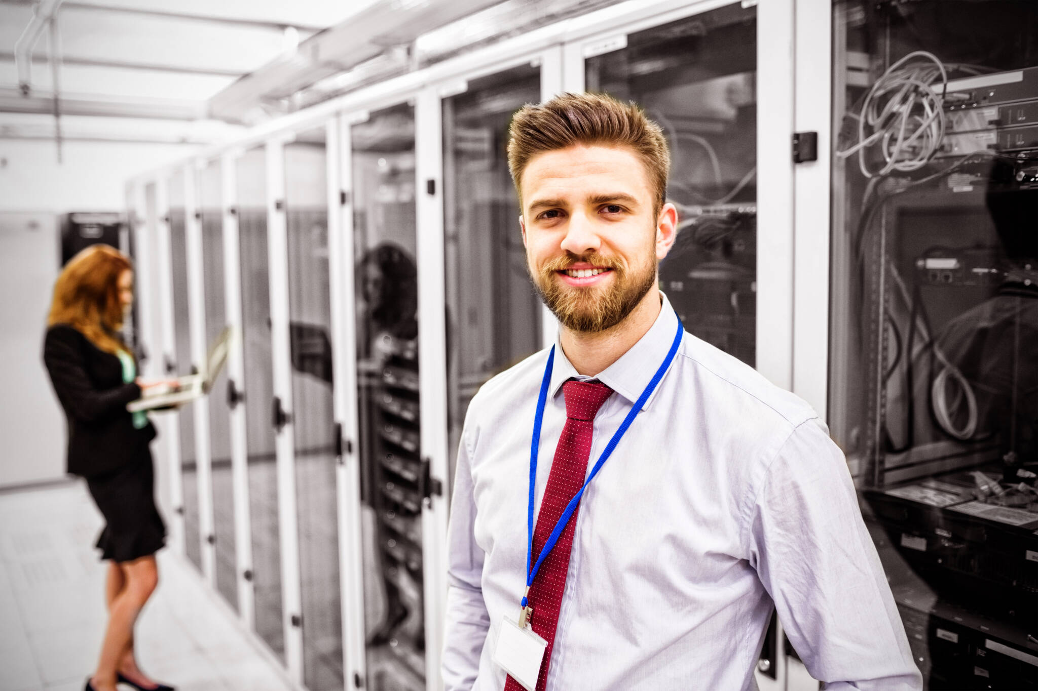 Smiling technician standing in a server room